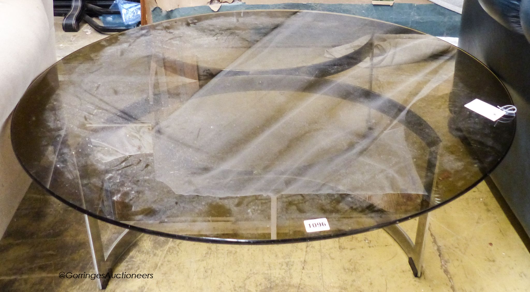 A Merrow style circular glass top table. D-100cm, H-32cm.